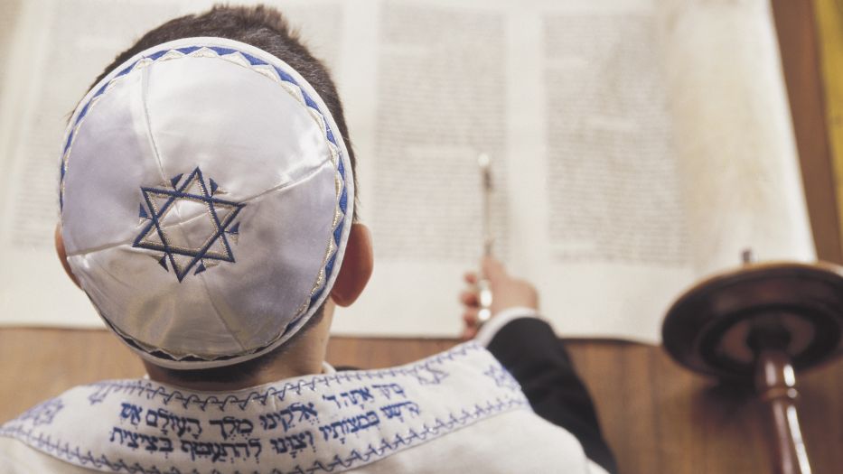 Boy in a kippah reading the Torah